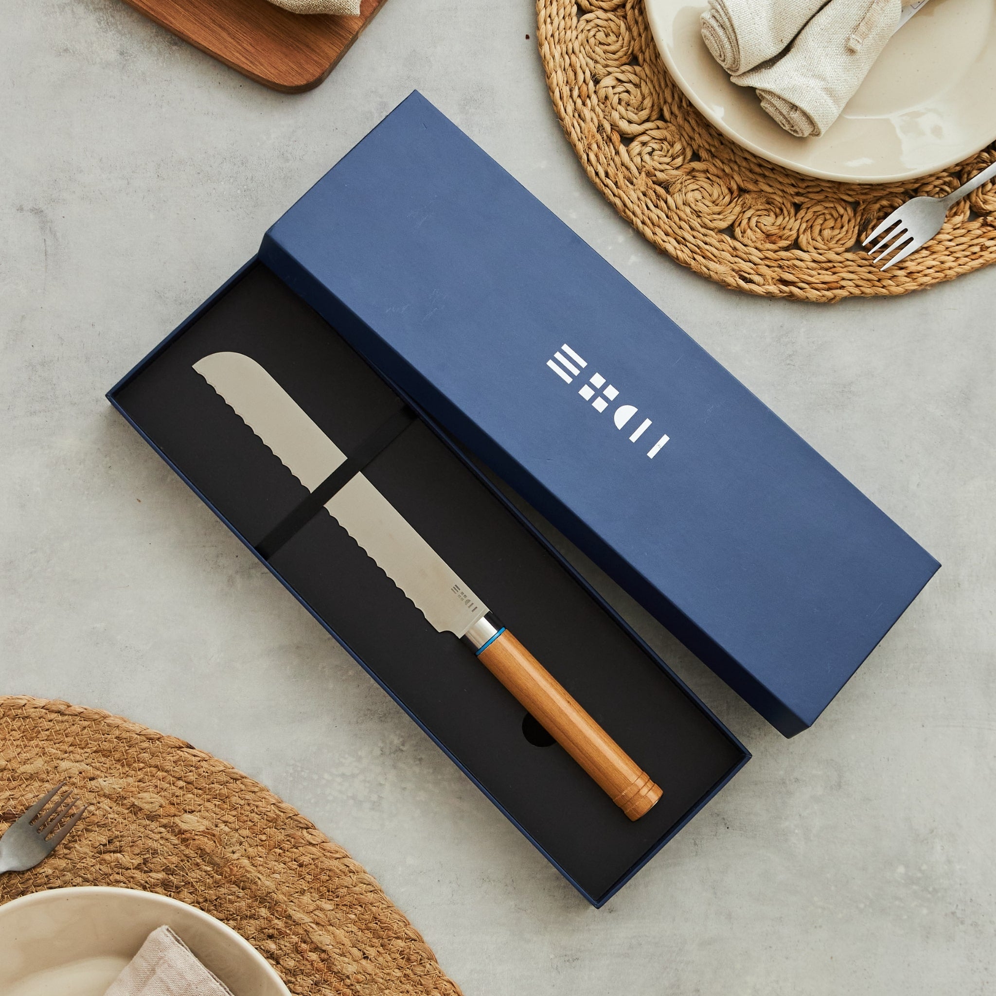 Couteau à pain ETCH présenté dans un coffret cadeau bleu marine profond, lame dentelée 22 cm et manche bois aux nervures naturelles