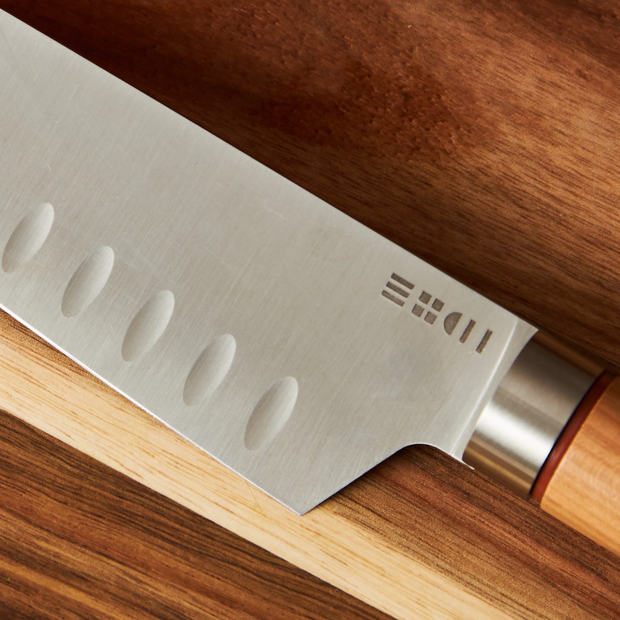 Détail de la lame alvéolée anti-adhérente du couteau Santoku ETCH pour émincer sans coller