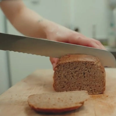 Vidéo macro du couteau à pain ETCH découpant une croûte épaisse avec aisance, sans écraser la mie ni accrocher la croûte